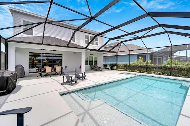 view of pool with glass enclosure and a patio area