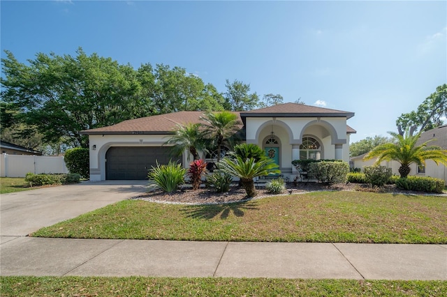 mediterranean / spanish house featuring a garage and a front yard