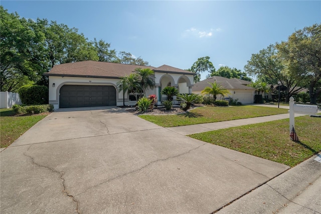 mediterranean / spanish home with a garage and a front yard