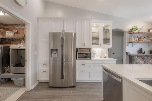 kitchen featuring white cabinetry, vaulted ceiling, and stainless steel appliances