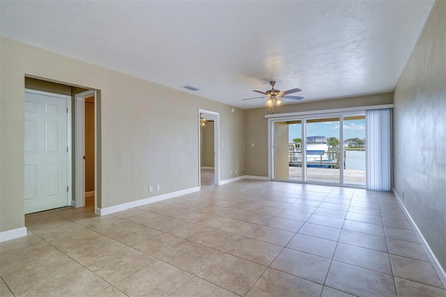 spare room featuring light tile patterned floors and ceiling fan