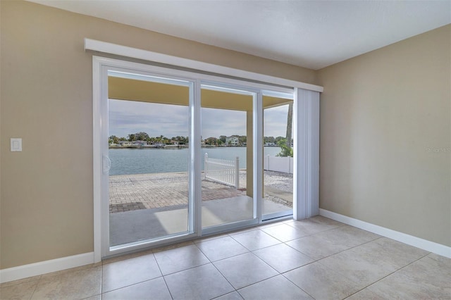 doorway to outside featuring a water view and light tile patterned floors