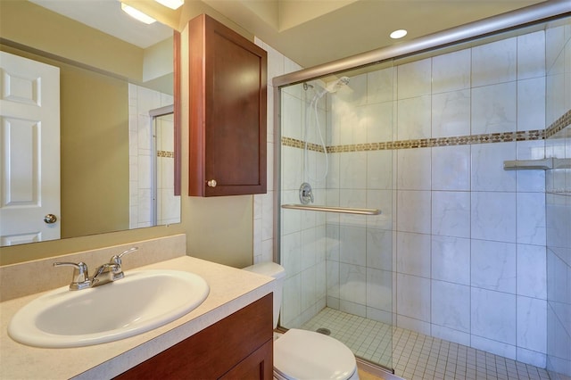 bathroom featuring vanity, toilet, and an enclosed shower