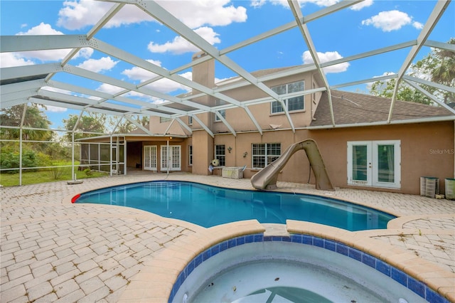 view of swimming pool with an in ground hot tub, a water slide, glass enclosure, and french doors