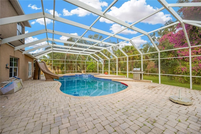 view of swimming pool featuring a patio, a lanai, area for grilling, and a water slide