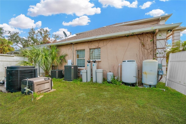 back of house featuring cooling unit and a lawn