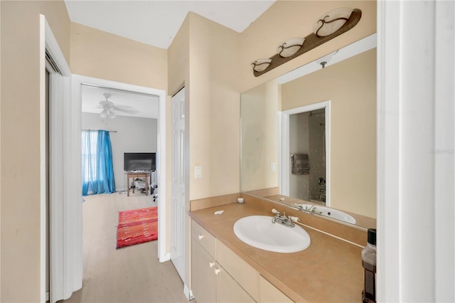 bathroom with hardwood / wood-style flooring, ceiling fan, and vanity