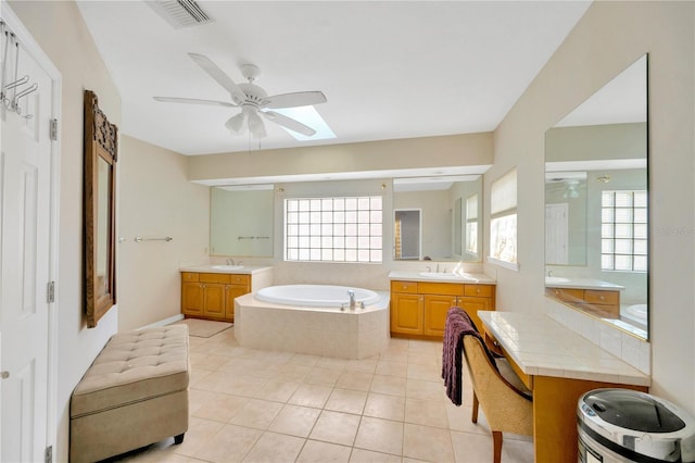 bathroom featuring tile patterned flooring, vanity, tiled bath, and ceiling fan