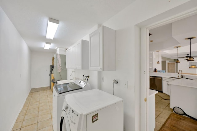 laundry room with sink, cabinets, a textured ceiling, light tile patterned floors, and independent washer and dryer