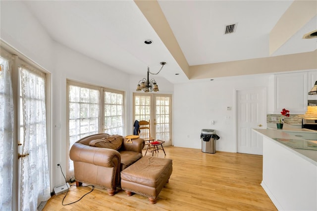 sitting room featuring french doors, a notable chandelier, and light wood-type flooring