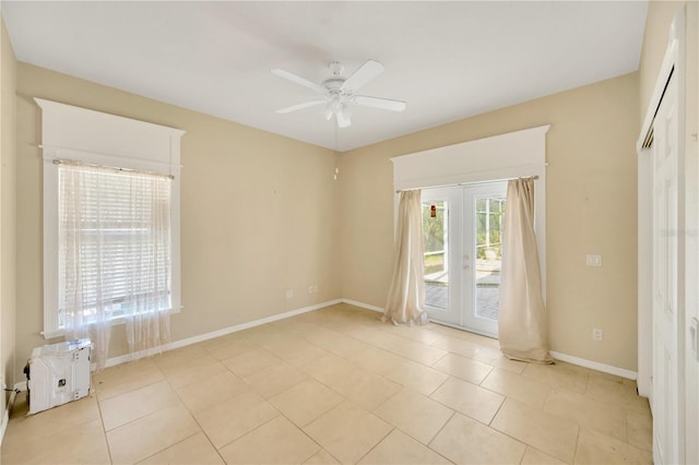 tiled empty room with ceiling fan and french doors