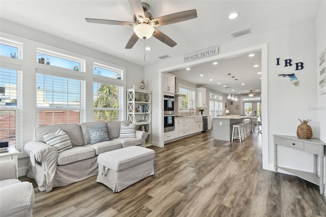 living room featuring dark hardwood / wood-style flooring, sink, and ceiling fan