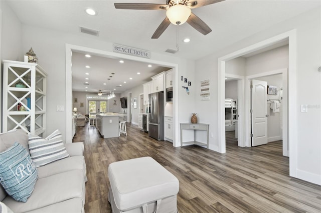 living room featuring dark wood-type flooring and ceiling fan