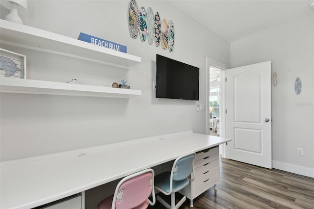 home office with dark wood-type flooring and built in desk