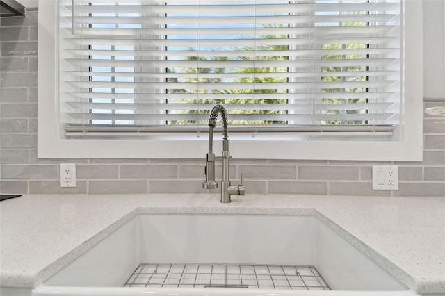 details featuring sink, backsplash, and light stone counters