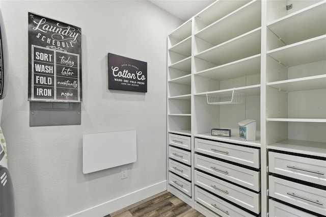 walk in closet with dark wood-type flooring