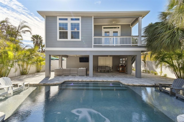 back of house with a fenced in pool, a patio, and an outdoor hangout area