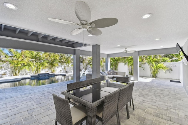 view of patio with an outdoor living space, ceiling fan, and a water view