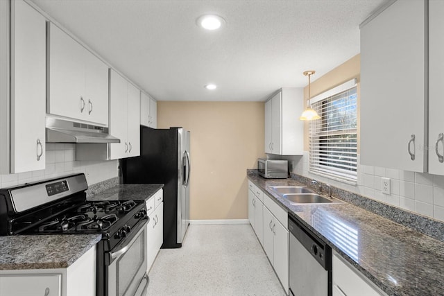 kitchen with decorative backsplash, white cabinets, pendant lighting, and appliances with stainless steel finishes