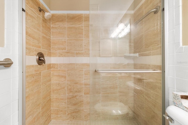 bathroom with tiled shower and toilet