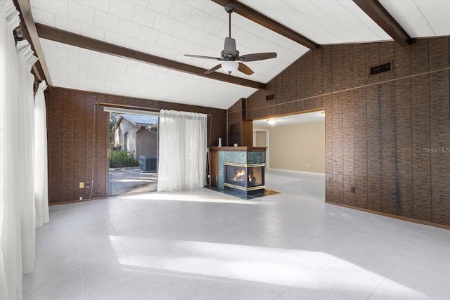 unfurnished living room with a multi sided fireplace, vaulted ceiling with beams, and ceiling fan