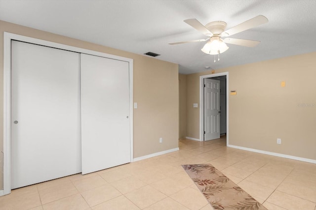 unfurnished bedroom with a closet, ceiling fan, and light tile patterned floors