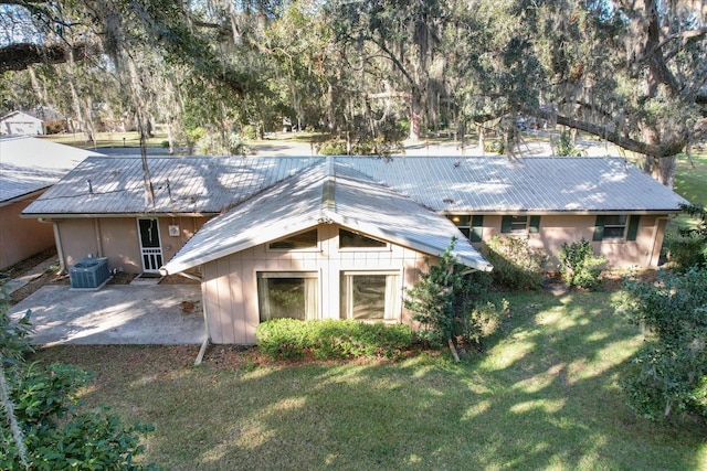 rear view of property featuring a patio, a lawn, and central air condition unit