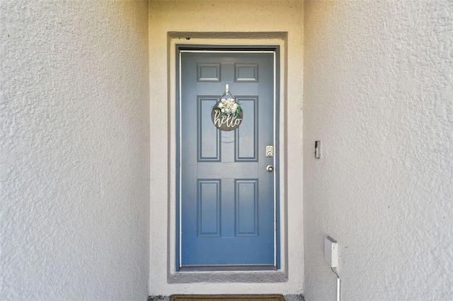 entrance to property featuring stucco siding