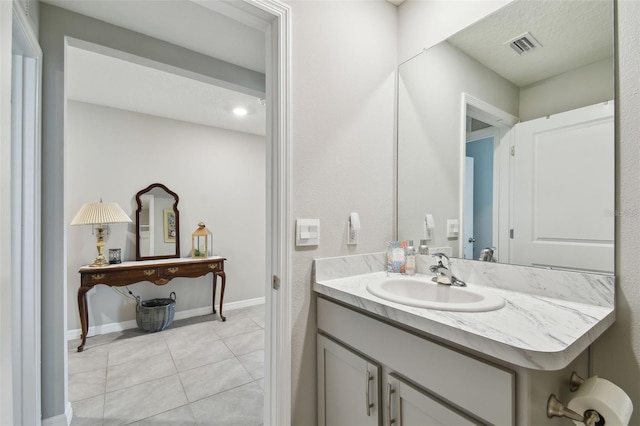 bathroom with visible vents, a textured ceiling, vanity, baseboards, and tile patterned floors