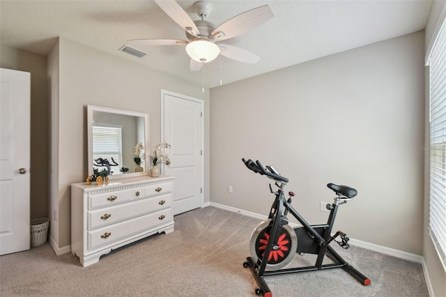 exercise area with baseboards, visible vents, and light colored carpet