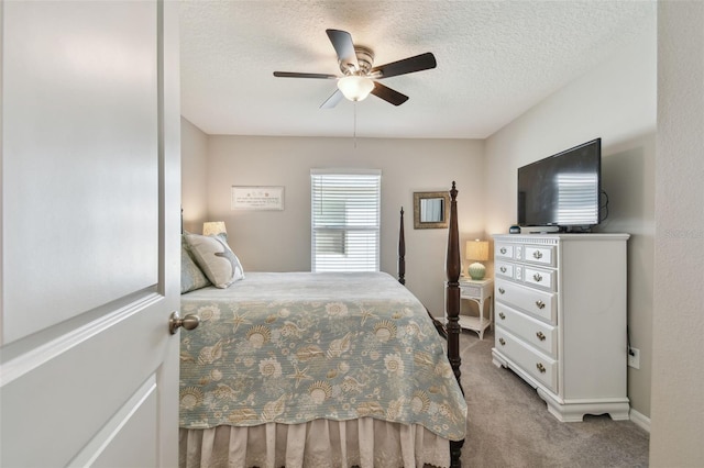 carpeted bedroom with a ceiling fan and a textured ceiling