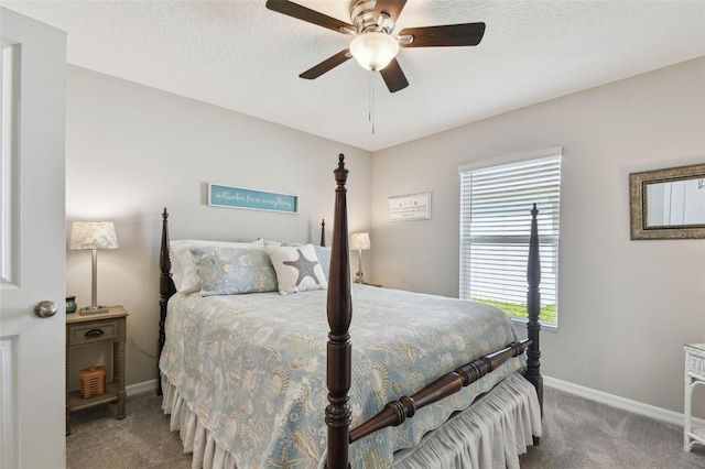 bedroom with carpet floors, baseboards, and a textured ceiling