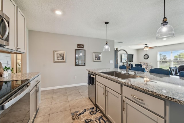 kitchen with hanging light fixtures, appliances with stainless steel finishes, light tile patterned flooring, and a sink