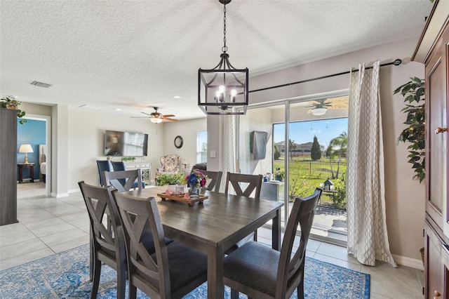 dining room featuring light tile patterned floors, a textured ceiling, visible vents, and baseboards