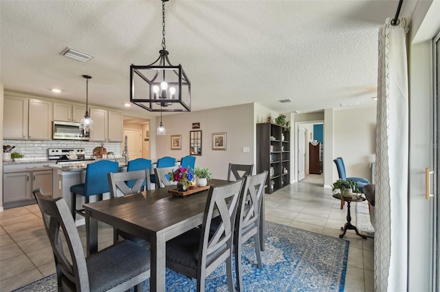 dining space featuring a textured ceiling, light tile patterned flooring, and visible vents