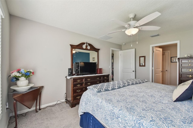 bedroom with light carpet, baseboards, visible vents, a ceiling fan, and a textured ceiling