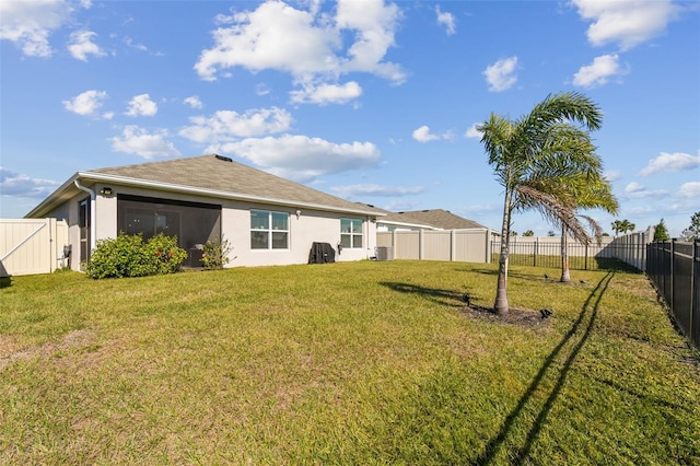 back of property featuring stucco siding, a fenced backyard, a gate, and a yard