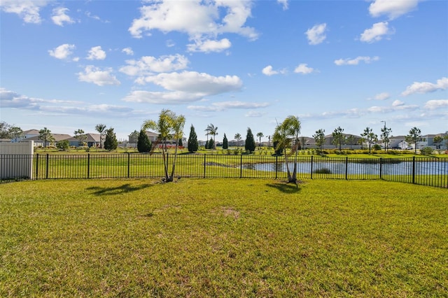 view of yard with a water view, a residential view, and fence