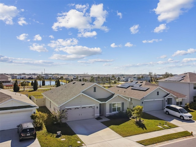 view of front of property with a residential view, concrete driveway, an attached garage, and a front lawn