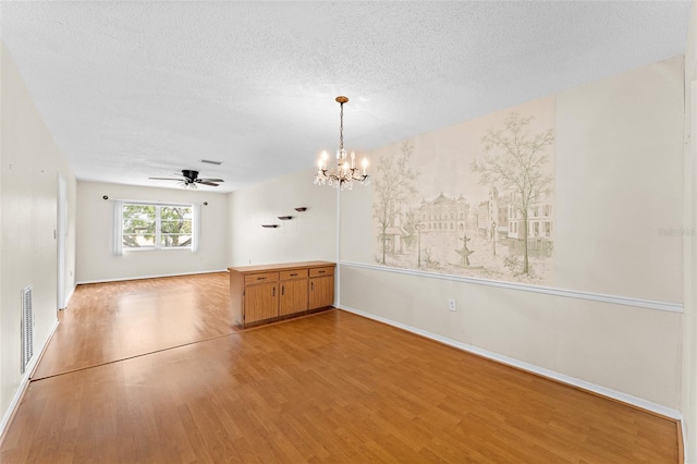 spare room featuring a textured ceiling, wood finished floors, and visible vents