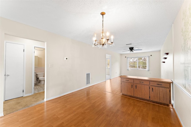 interior space featuring visible vents, a textured ceiling, and light wood finished floors