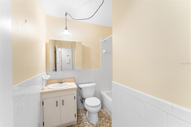 full bath with shower / bath combination, wainscoting, toilet, vanity, and tile walls