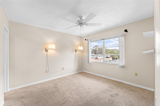 spare room with carpet, baseboards, ceiling fan, and a textured ceiling