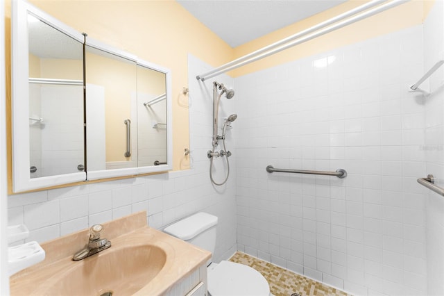 bathroom featuring decorative backsplash, a tile shower, vanity, and toilet