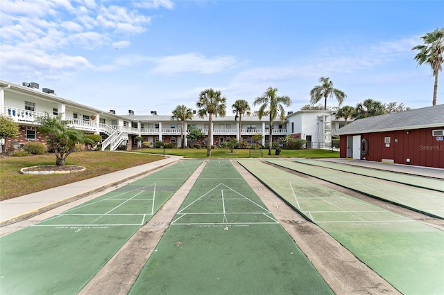 view of property's community with a yard and shuffleboard