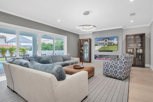 living room with ornamental molding and light hardwood / wood-style floors