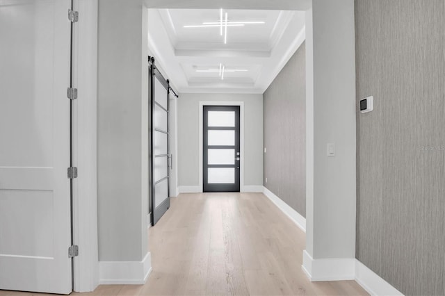 entrance foyer with crown molding, light hardwood / wood-style floors, and a barn door