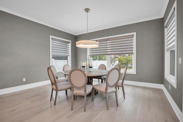 dining space featuring ornamental molding and light hardwood / wood-style floors