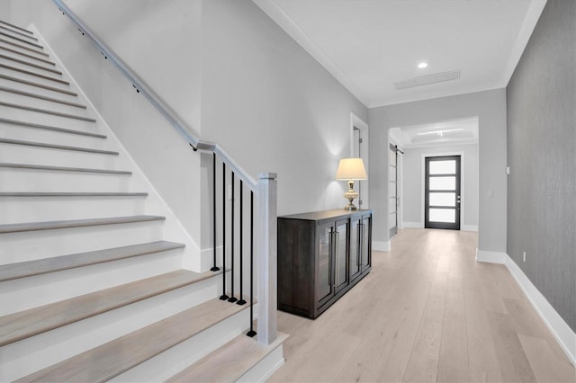 foyer entrance featuring ornamental molding and light hardwood / wood-style flooring