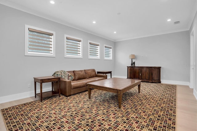 living room with ornamental molding and light hardwood / wood-style floors